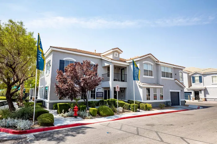 Beautiful apartment building with well-maintained landscaping and bright exterior on a sunny day.
