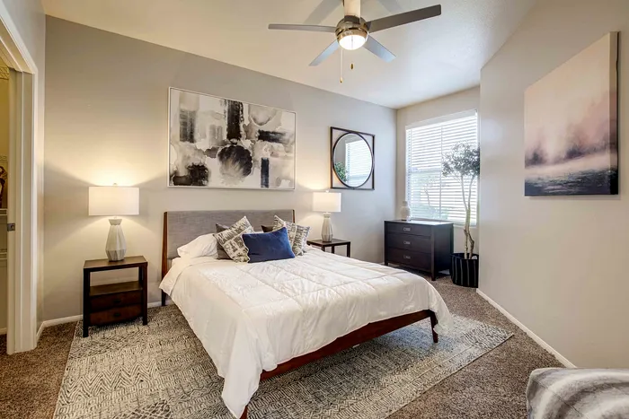 Sophisticated bedroom with modern decor, featuring a plush bed, stylish artwork, and ample natural light.
