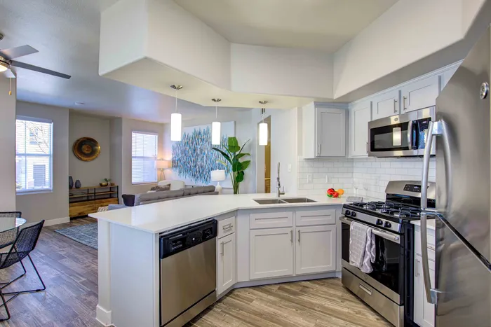 Bright, open-concept kitchen with modern appliances leading to a cozy living room.
