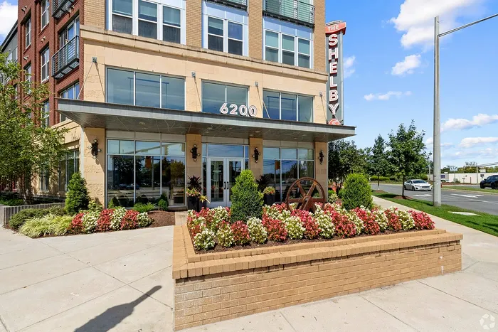 Charming urban apartment building with modern facade, vibrant landscaping, and inviting entrance at The Shelby.