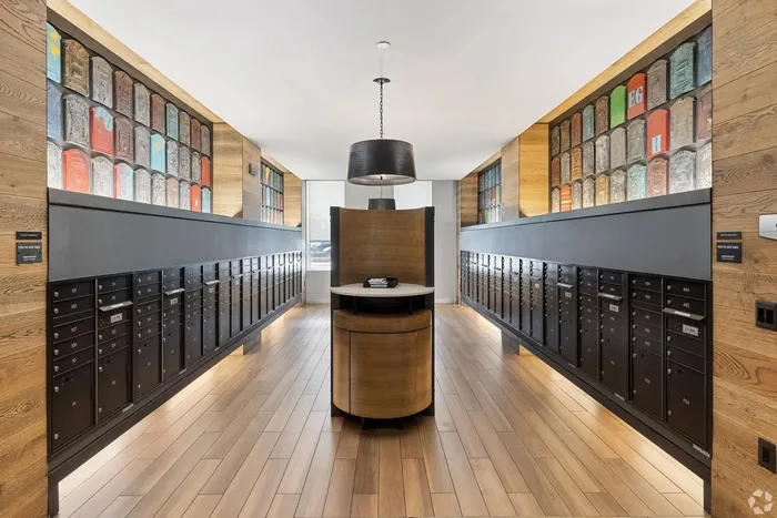 Chic apartment lobby showcasing modern mailboxes with unique artwork, stylish wood paneling, and elegant lighting.