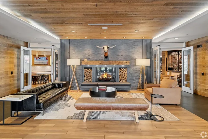 Inviting living space with a rustic charm, featuring a cozy fireplace, modern leather seating, and warm wooden accents.