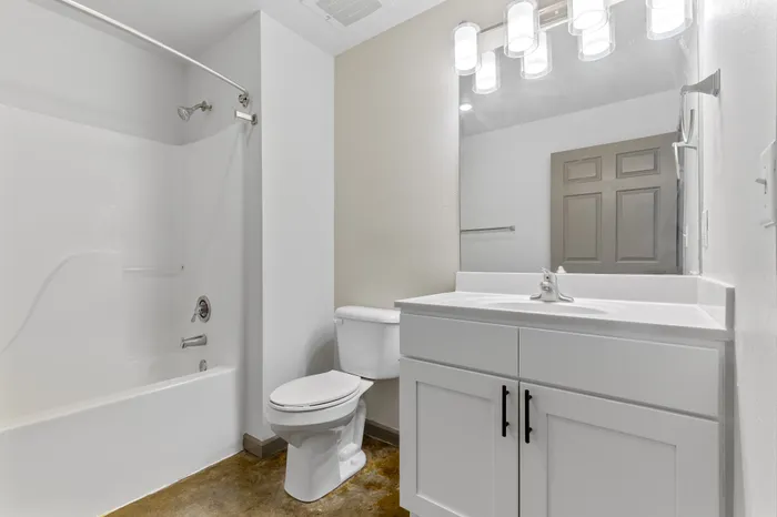 Bright modern bathroom with sleek fixtures, spacious vanity, and elegant lighting.