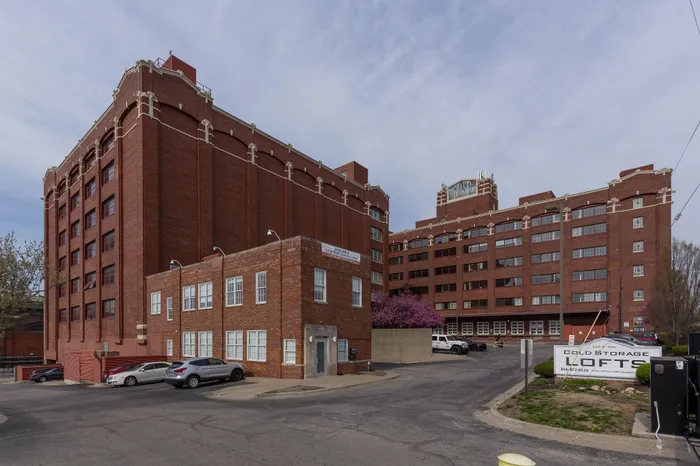 Charming brick loft building with ample windows, offering stylish urban living and convenient parking.