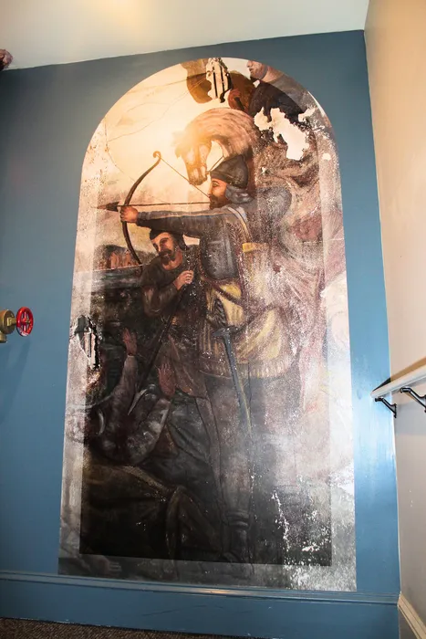 Dramatic mural depicting historical archers and a horse, adding elegance and character to the apartment interior.