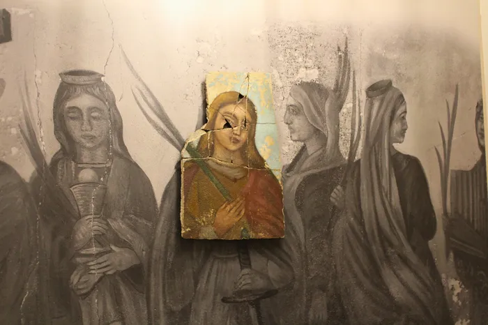 Intriguing artistic wall mural featuring a vibrant central piece with a colorfully detailed figure surrounded by grayscale figures, creating a striking contrast.