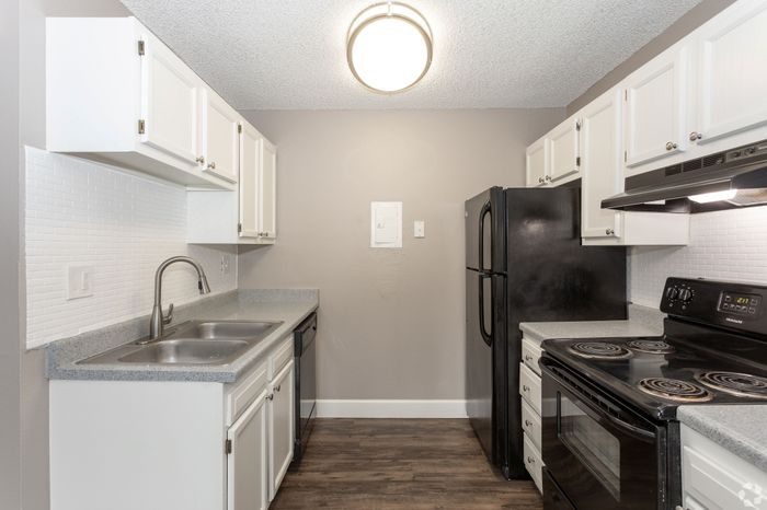 Modern kitchen with sleek black appliances, white cabinetry, and elegant countertops, offering a stylish and functional cooking space.