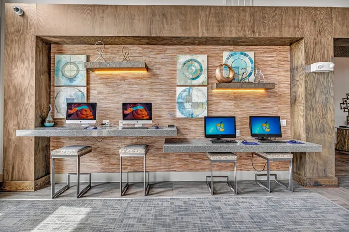 Modern and inviting workspace with four sleek computer stations, stylish decor, and unique artwork, perfect for productivity and creativity.