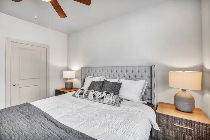 Elegant bedroom with a plush tufted bed and modern bedside lamps for a cozy atmosphere.