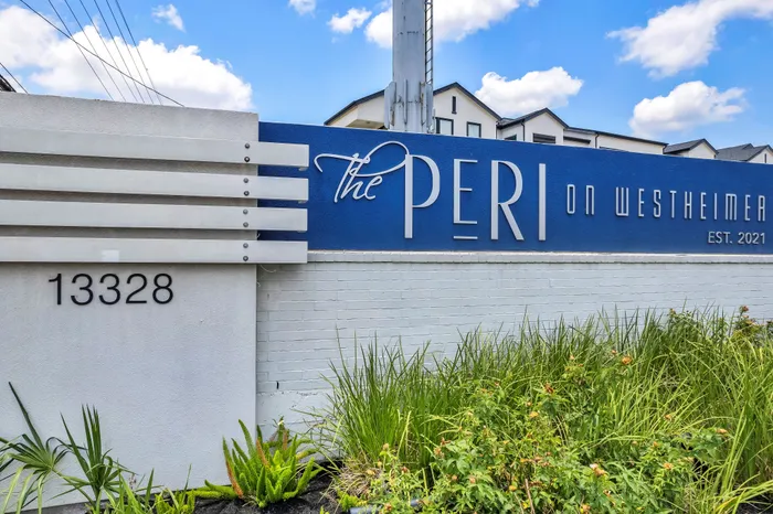 Welcome to The Peri on Westheimer, a modern establishment with a striking blue and white exterior, surrounded by lush landscaping, established in 2021.
