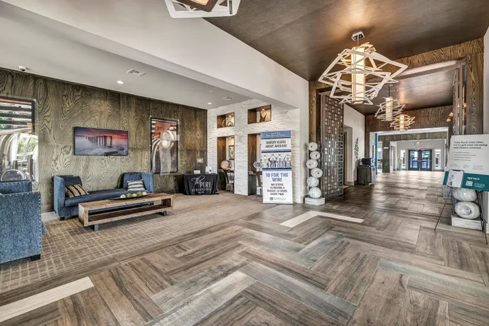 Elegant apartment lobby featuring stylish wooden flooring, modern decor, and cozy seating area with contemporary lighting.