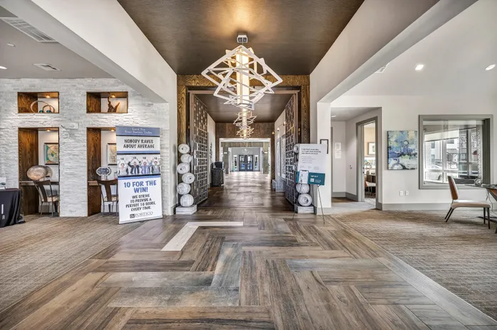 Elegant apartment lobby featuring stylish geometric lighting, modern decor, and a striking herringbone floor design.