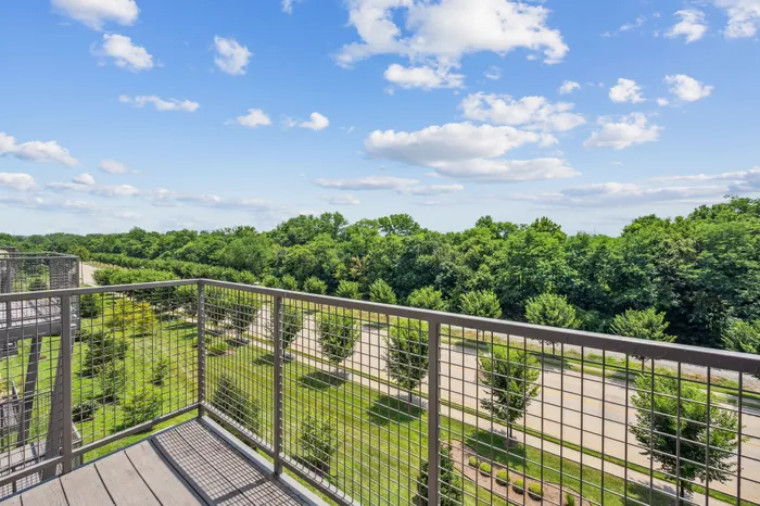 Scenic balcony view showcasing lush greenery and a serene park setting, perfect for relaxation and tranquility.