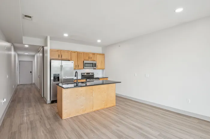 Modern open-concept kitchen with sleek countertops, stainless steel appliances, and elegant wood cabinetry.