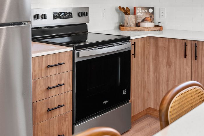 Modern kitchen corner with sleek stainless steel appliances, elegant wooden cabinetry, and a sophisticated countertop, perfect for cooking enthusiasts.
