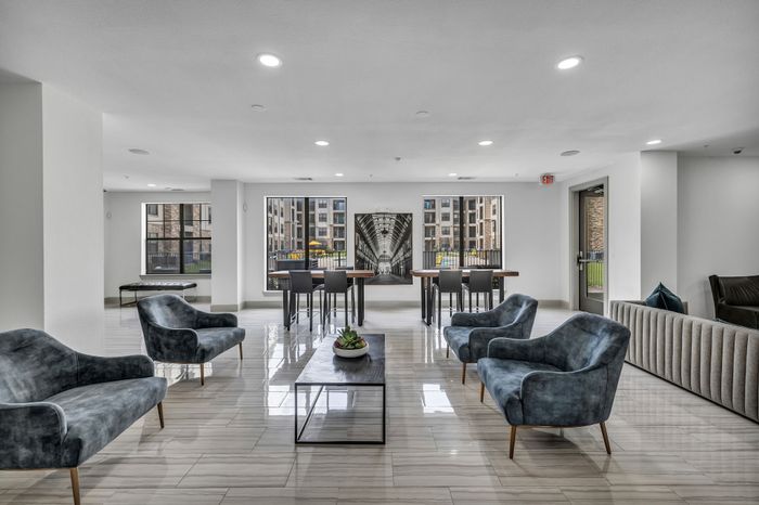 Modern communal lounge with elegant seating, large windows, and stylish decor offering a welcoming ambiance.