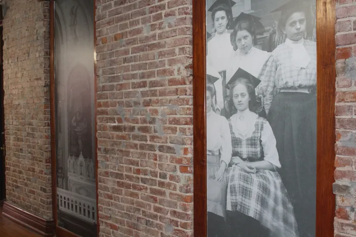 Charming apartment hallway with exposed brick walls and a vintage black-and-white photo display, adding character and historical allure.