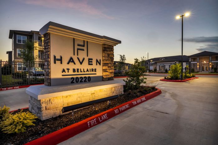 Inviting evening view of Haven at Bellaire, showcasing stylish stone accents and modern, well-lit exterior.