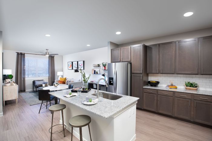Modern open-concept kitchen and living area with sleek cabinetry, stainless steel appliances, and cozy living space.
