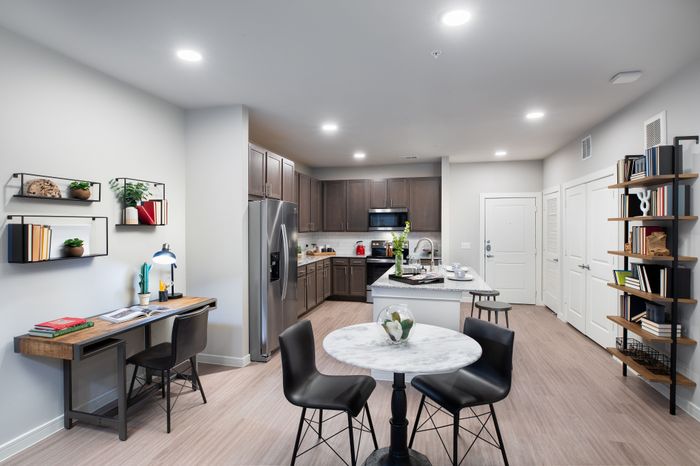 Contemporary apartment kitchen and dining area with sleek cabinetry, modern appliances, and stylish decor.