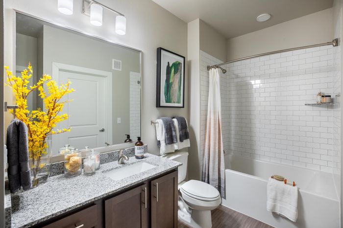 Elegant bathroom design featuring a sleek granite countertop, vibrant yellow florals, and chic subway tile accents.