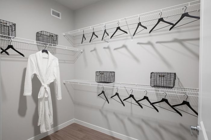 Spacious walk-in closet with sleek wire shelving and modern black hangers, offering ample storage space and organization options.