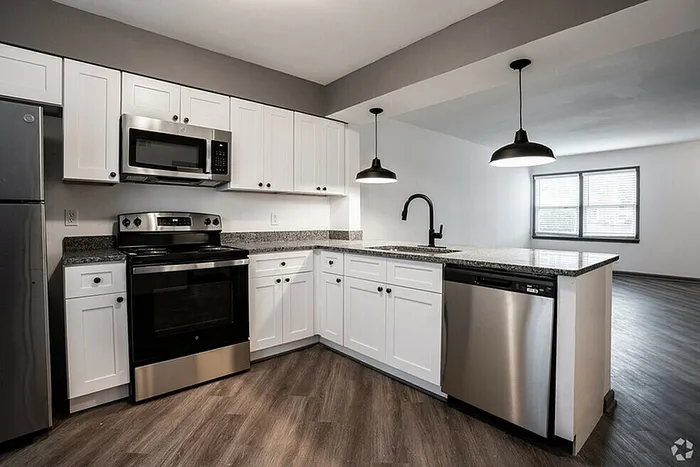 Modern kitchen with sleek stainless steel appliances, elegant white cabinetry, and a spacious granite countertop, perfect for culinary enthusiasts.