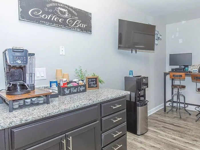 Chic apartment corner with a luxurious coffee bar featuring a modern coffee maker, complemented by sleek granite countertops and stylish bar stools.