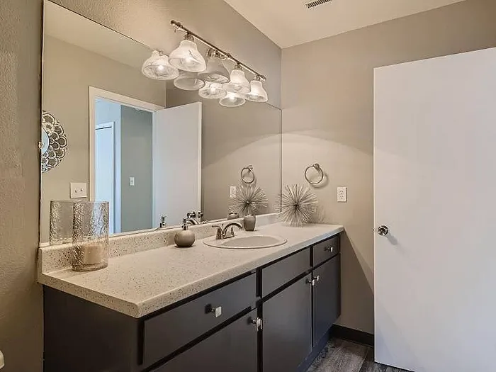 Modern bathroom with elegant lighting, stylish countertop, and contemporary decor accents.