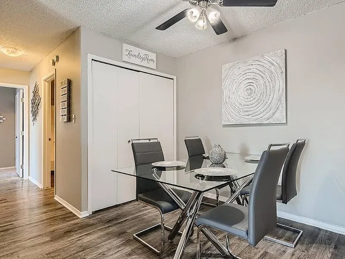 Sleek dining area with a modern glass table, stylish chairs, and elegant decor, exuding contemporary charm.