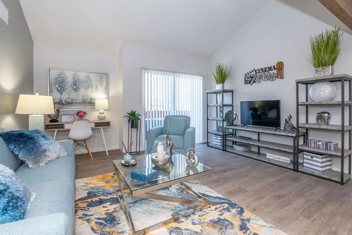 Chic living room showcasing modern decor with a plush blue sofa, elegant coffee table, and stylish shelving, exuding a cozy ambiance.