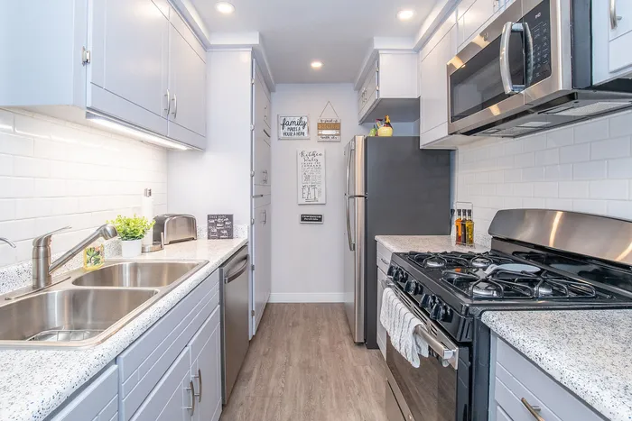 Charming modern kitchen with sleek stainless steel appliances and elegant white cabinetry.