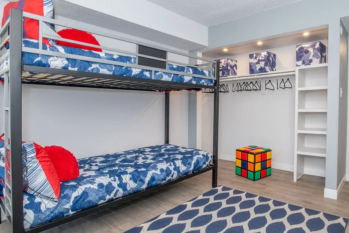 Charming kids' bedroom featuring colorful bunk beds, playful decor, and ample storage space.