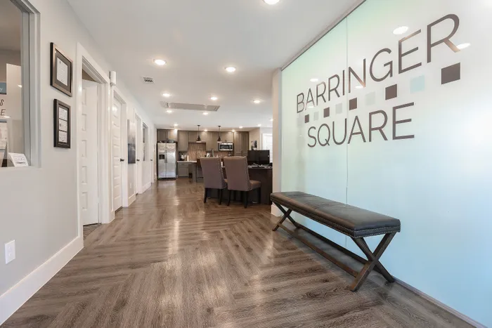Modern office space at Barringer Square with sleek hardwood floors, stylish seating, and an inviting kitchen area.