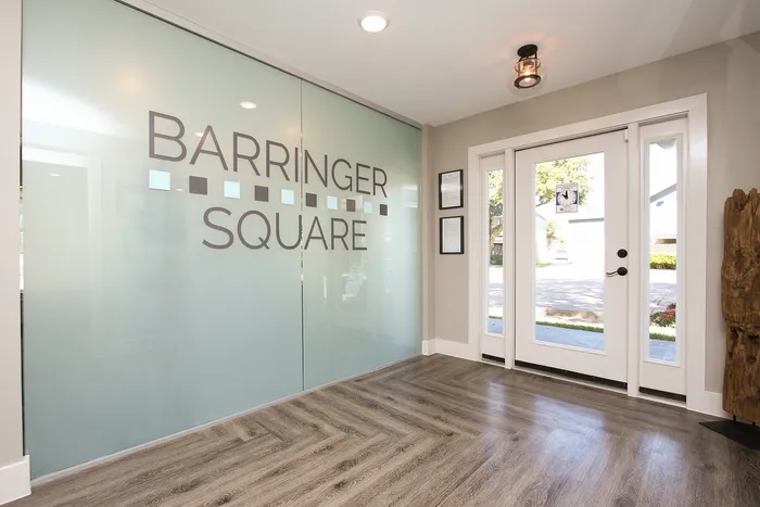 Chic and modern entryway at Barringer Square with stylish flooring and frosted glass doors, welcoming natural light.
