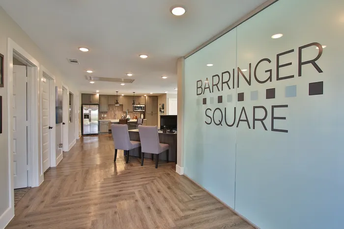 Elegant open-concept kitchen and dining area at Barringer Square, featuring sleek cabinetry and modern lighting.