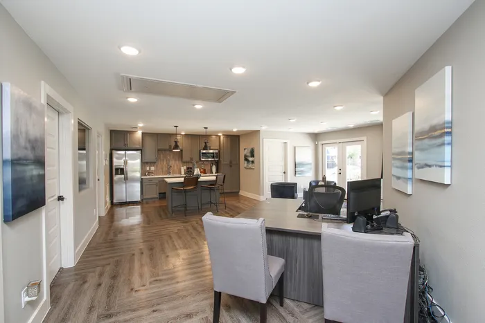 Contemporary open-plan kitchen and dining area with sleek cabinetry, modern appliances, and elegant wood flooring.