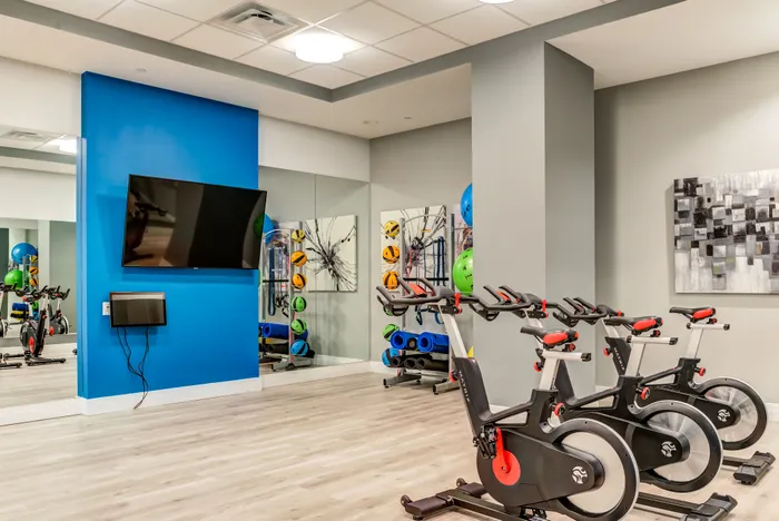 Modern fitness area featuring sleek exercise bikes and vibrant wall decor, ideal for energizing workouts.
