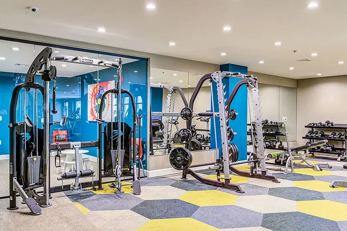 Modern apartment complex gym with state-of-the-art fitness equipment and vibrant decor, offering a dynamic workout experience.