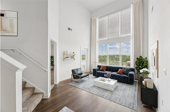 Bright and airy living room with high ceilings, modern decor, and large windows offering beautiful views.