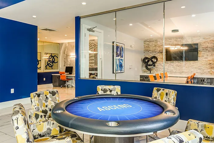 Vibrant meeting room with bold blue accents, featuring a poker table and modern seating.