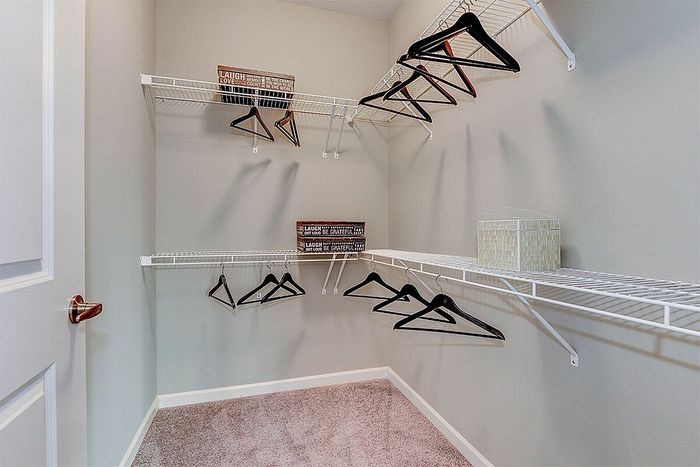 Spacious walk-in closet with elegant shelving and ample space for organization, ideal for fashion enthusiasts.