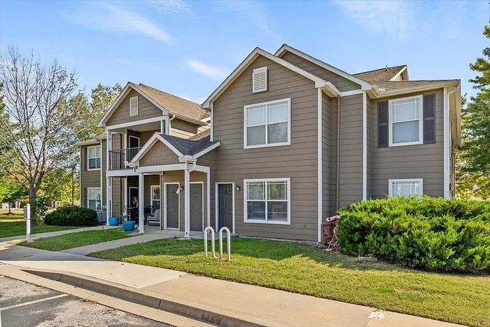 Charming townhouse exterior with modern architecture, featuring welcoming entrance and lush greenery.