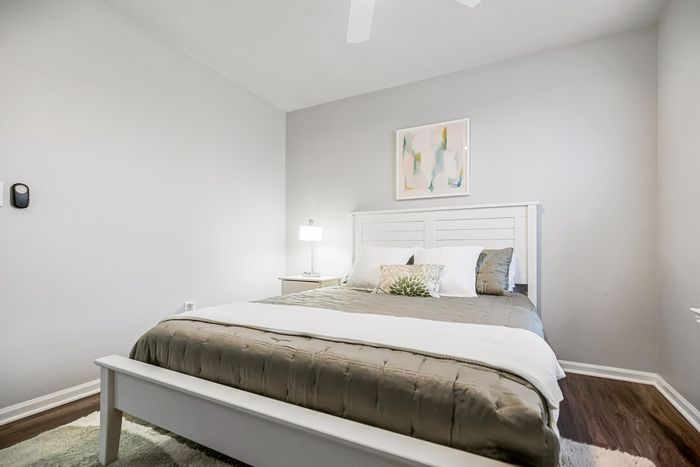 Chic bedroom with plush bedding, elegant nightstand, and contemporary art, offering a serene and stylish retreat.