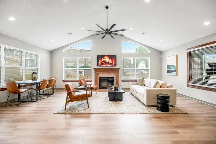 Inviting living room with abundant natural light, featuring a modern fireplace, cozy seating, and sleek dining space, perfect for relaxation and entertaining.