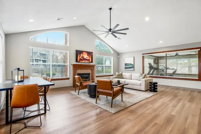 Bright, contemporary living space with high ceilings, a cozy fireplace, and stylish furniture, perfect for relaxation and entertaining.