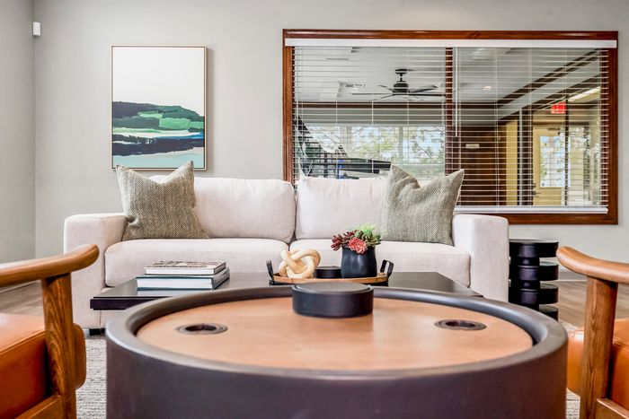 Chic, contemporary living room with a cozy white sofa, elegant abstract artwork, and stylish decor touches offering a serene atmosphere.