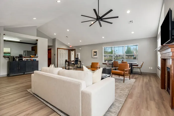 Contemporary living room with high ceilings, elegant lighting, and modern furniture, featuring a cozy fireplace and ample natural light.