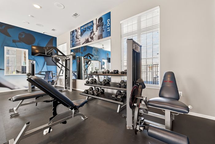 Modern fitness center with state-of-the-art exercise equipment, natural light, and motivational decor for an invigorating workout experience.