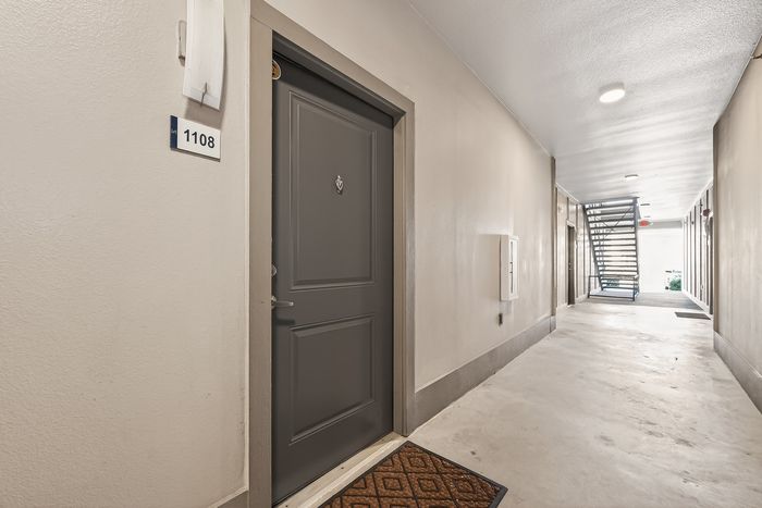 Welcoming apartment entrance with a sleek, modern door at unit 1108 in a bright, well-maintained hallway.